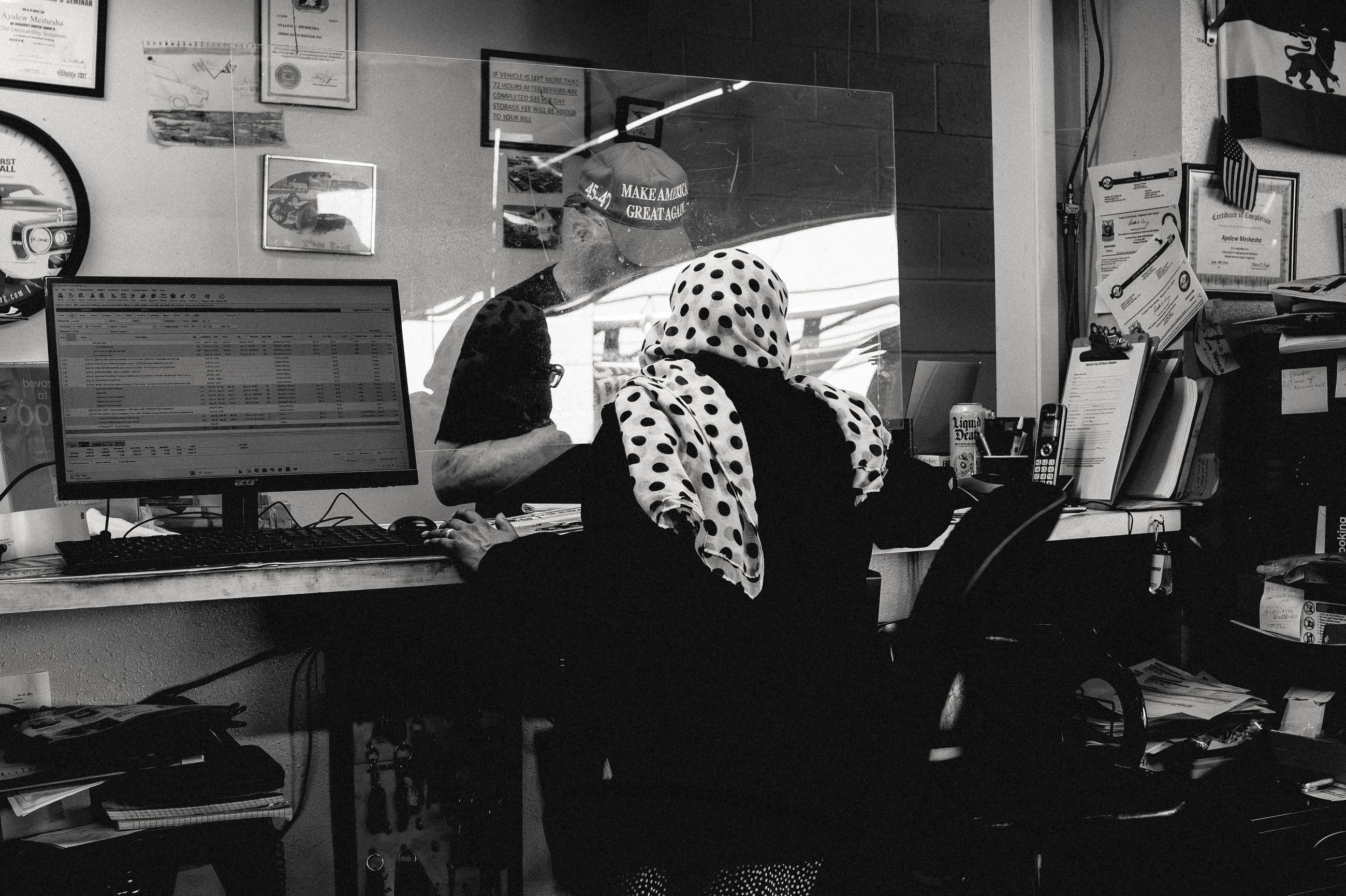 Ethiopian immigrant ringing out a MAGA man at the register of her shop.